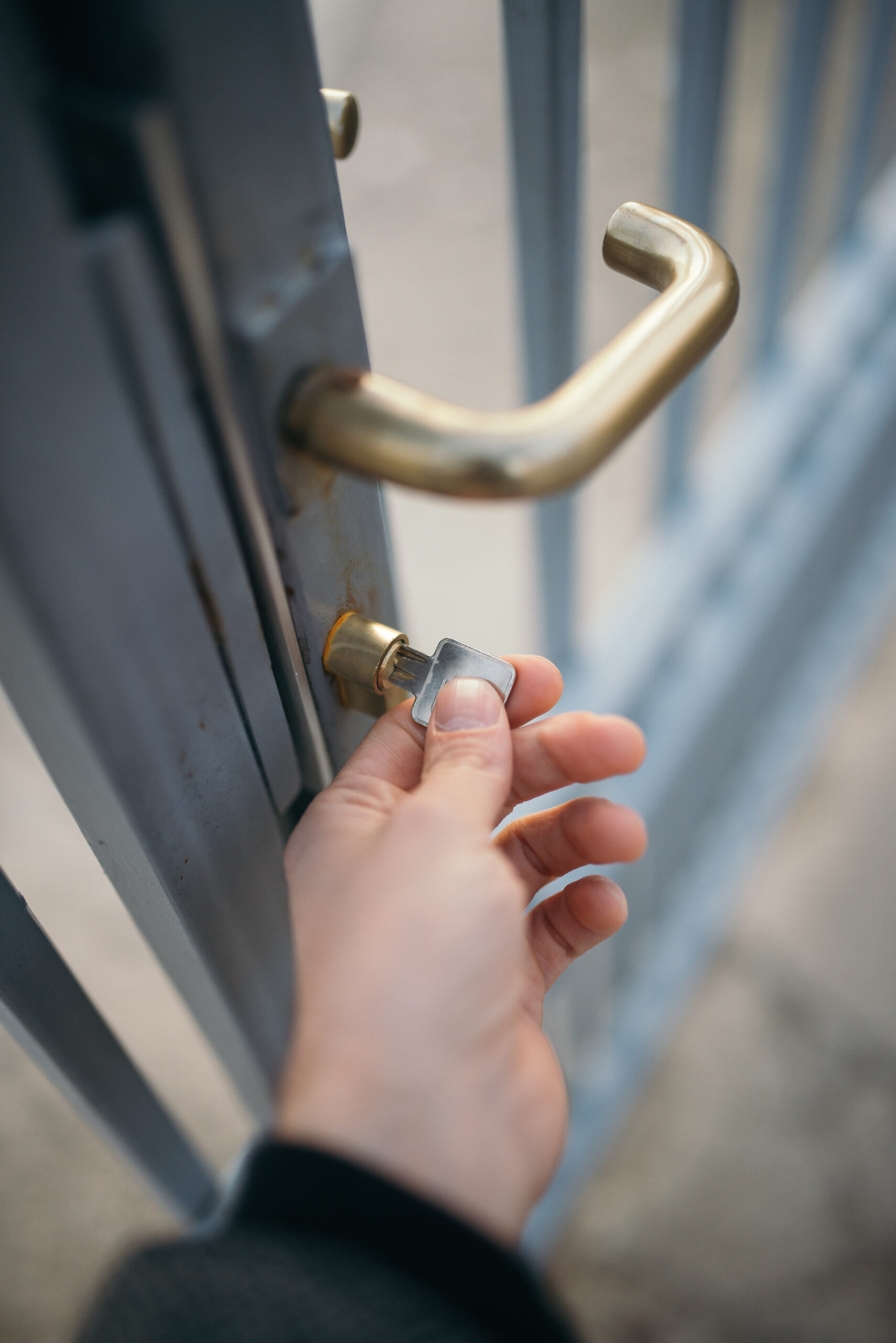 Hand inserting a key into a front door lock of a family home