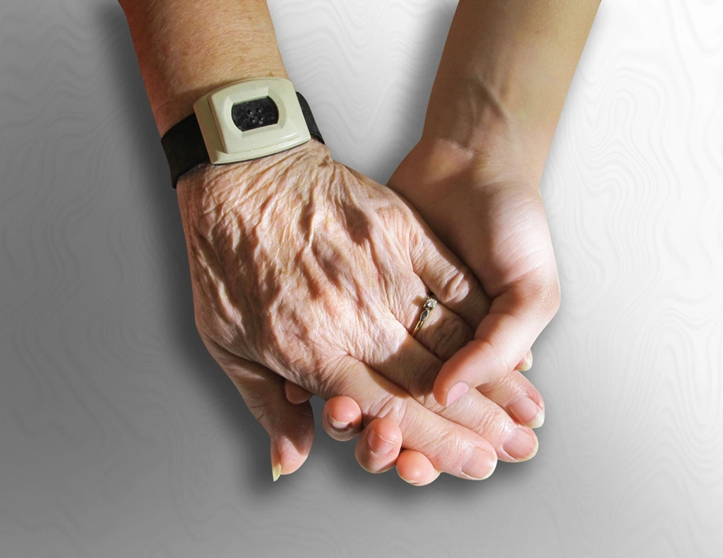 A warm, gentle moment of holding hands in comfort and support