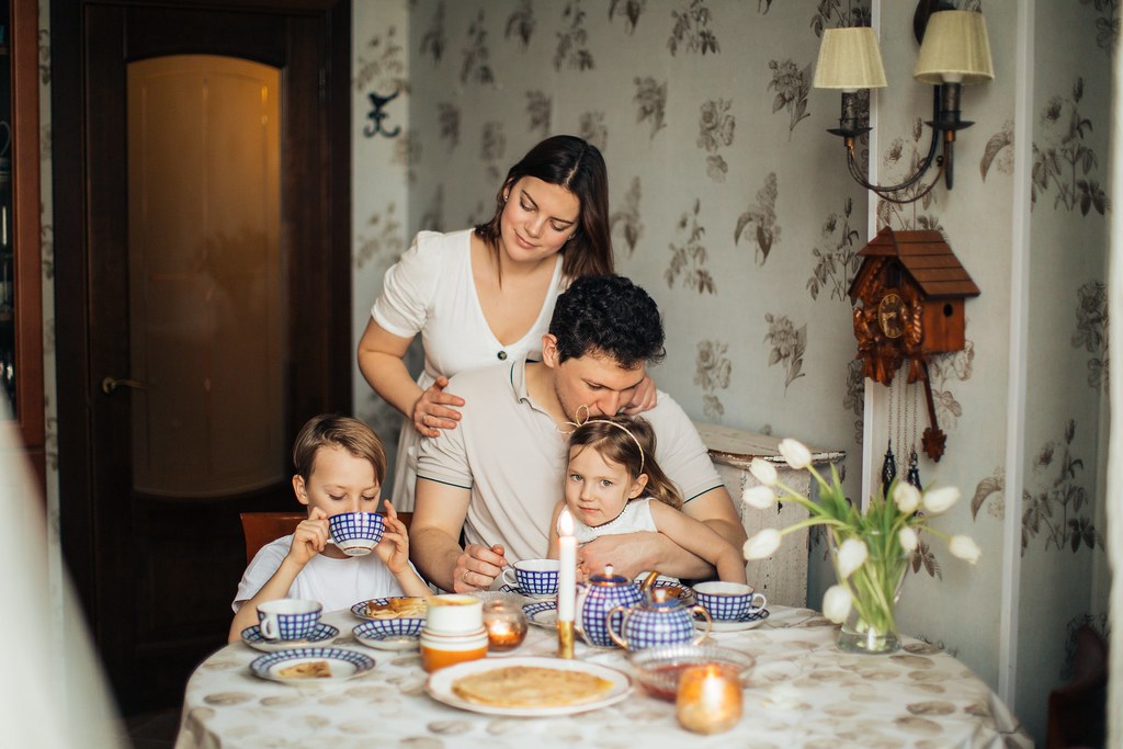 Family sitting together at the kitchen table having a conversation at home